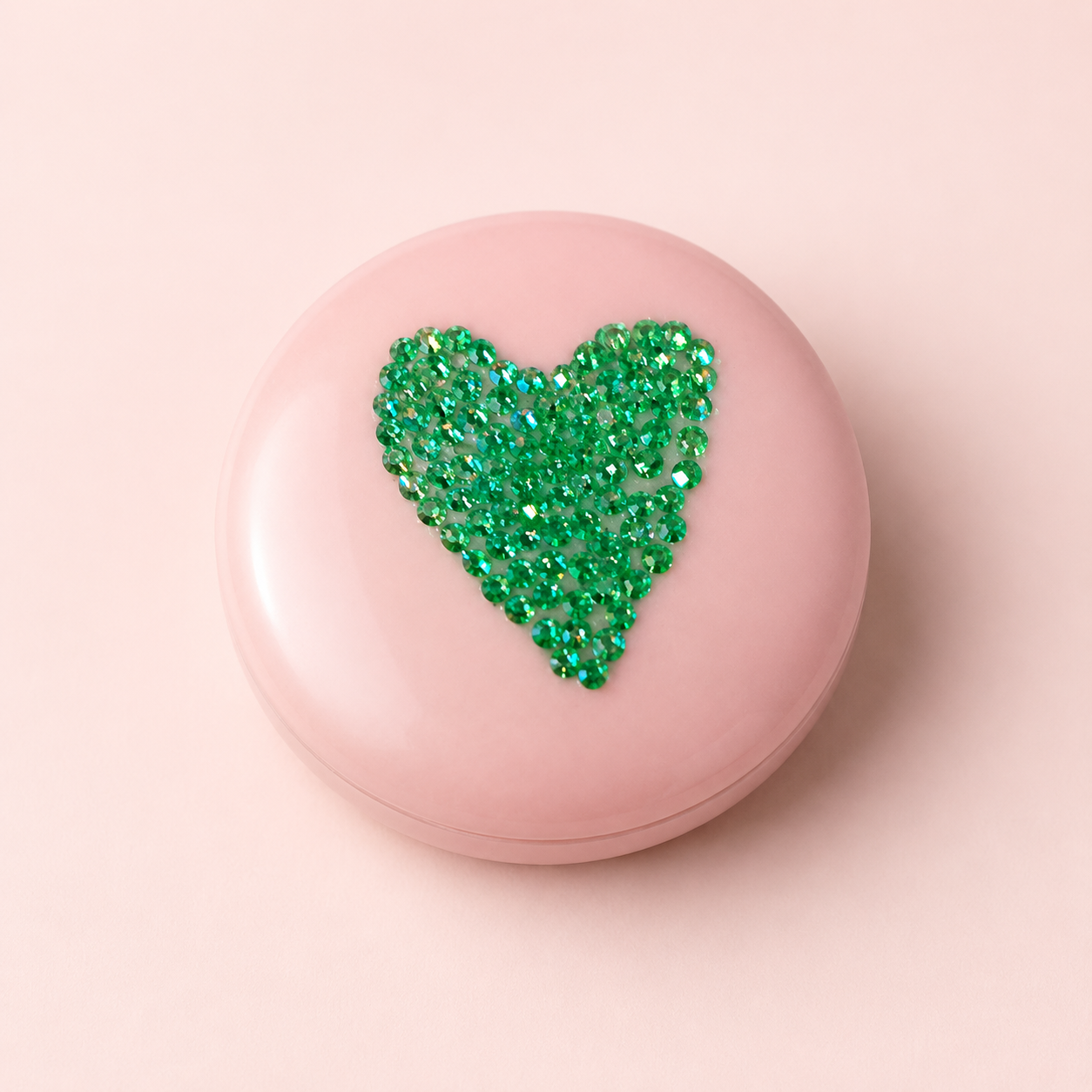 Pale pink compact mirror decorated with a green rhinestone heart